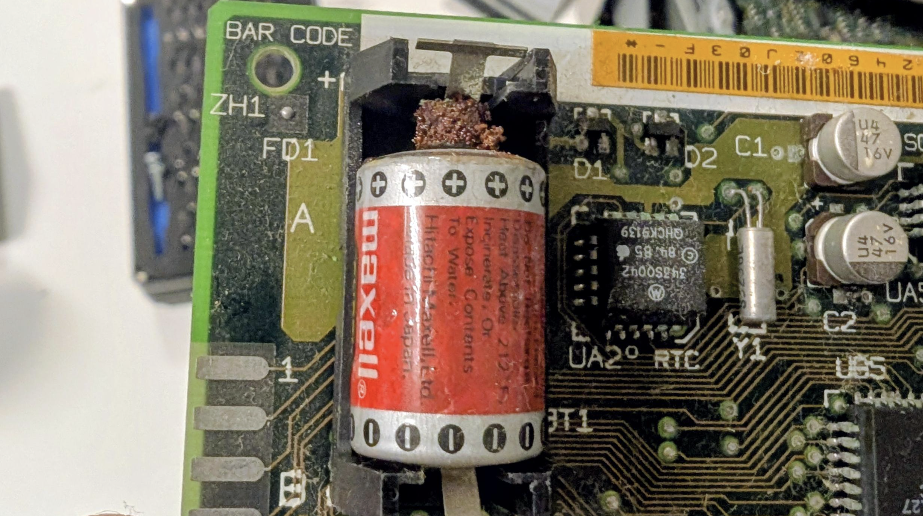 Closeup of a leaky battery on a logic board